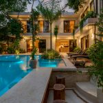 modern above ground backyard pool surrounded by plants and trees